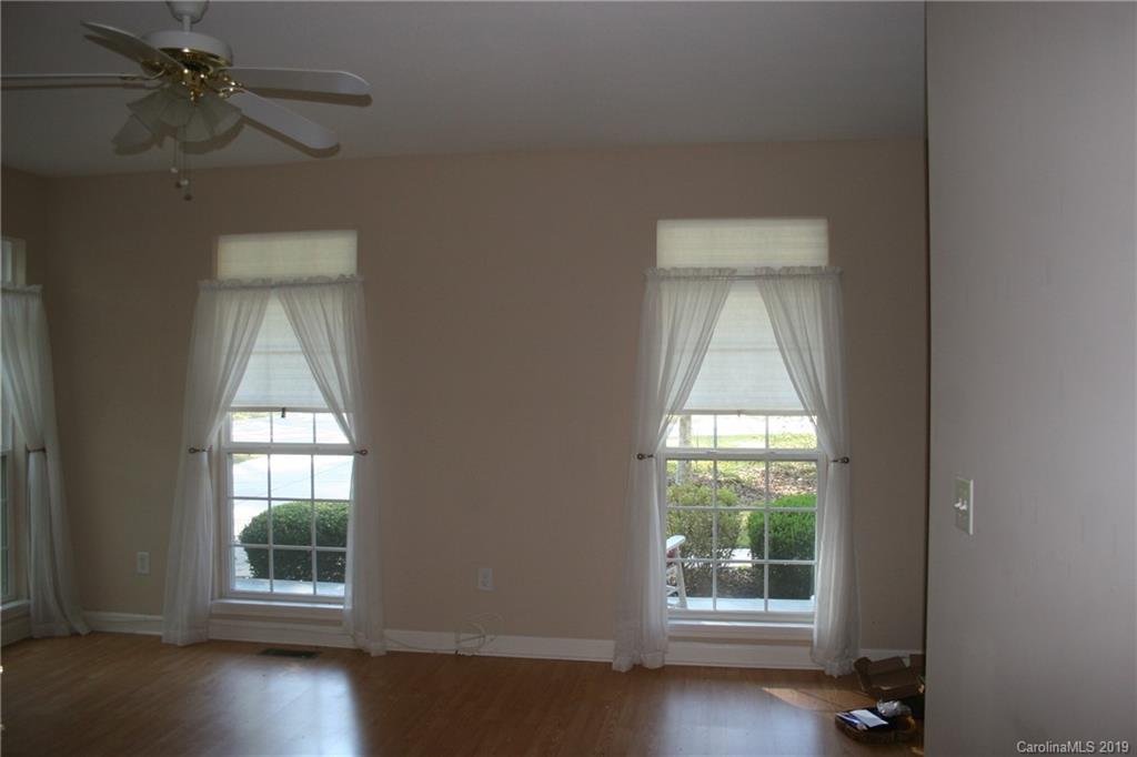 805 Stratford Road Troutman, NC 28166 - Photo 7 of 34 an empty room with wooden floor fan and windows