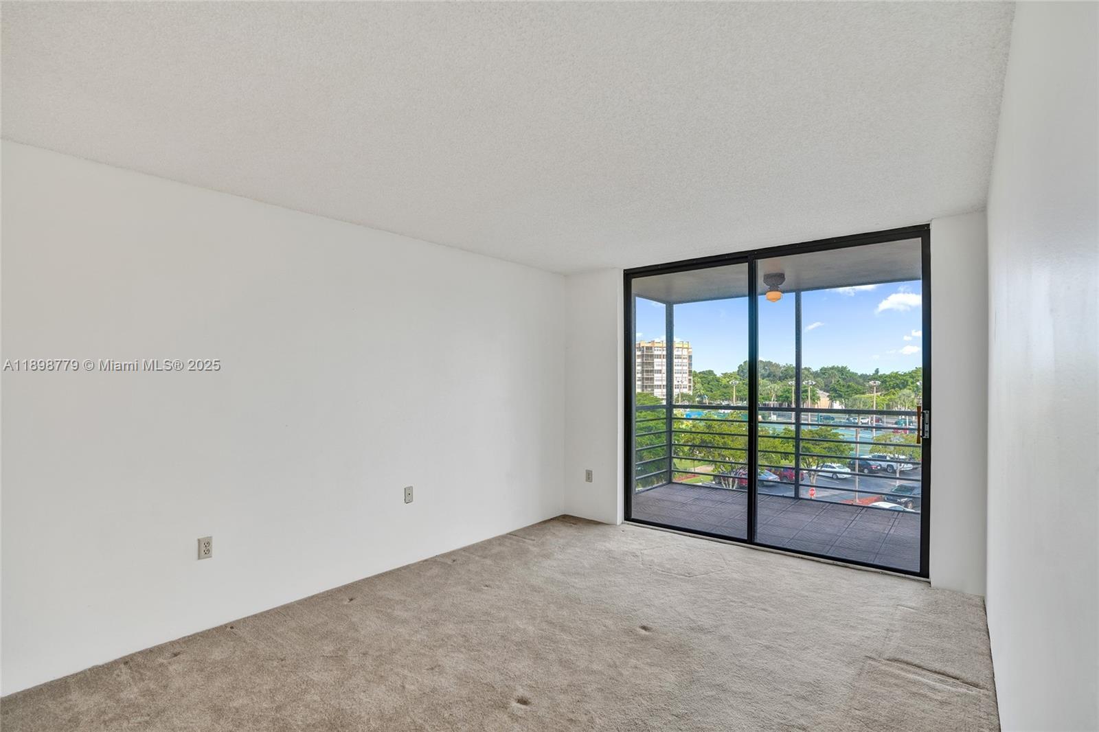 1200 St Charles Place, Unit 413 Pembroke Pines, FL 33026 - Photo 11 of 34 a view of an empty room with a sliding door