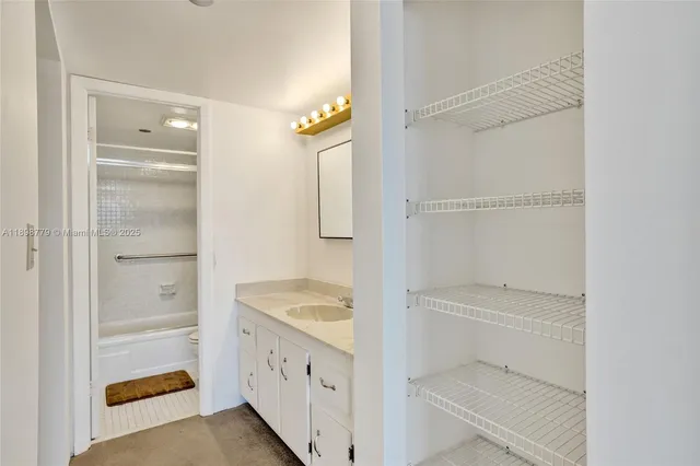 a bathroom with a granite countertop sink and a shower
