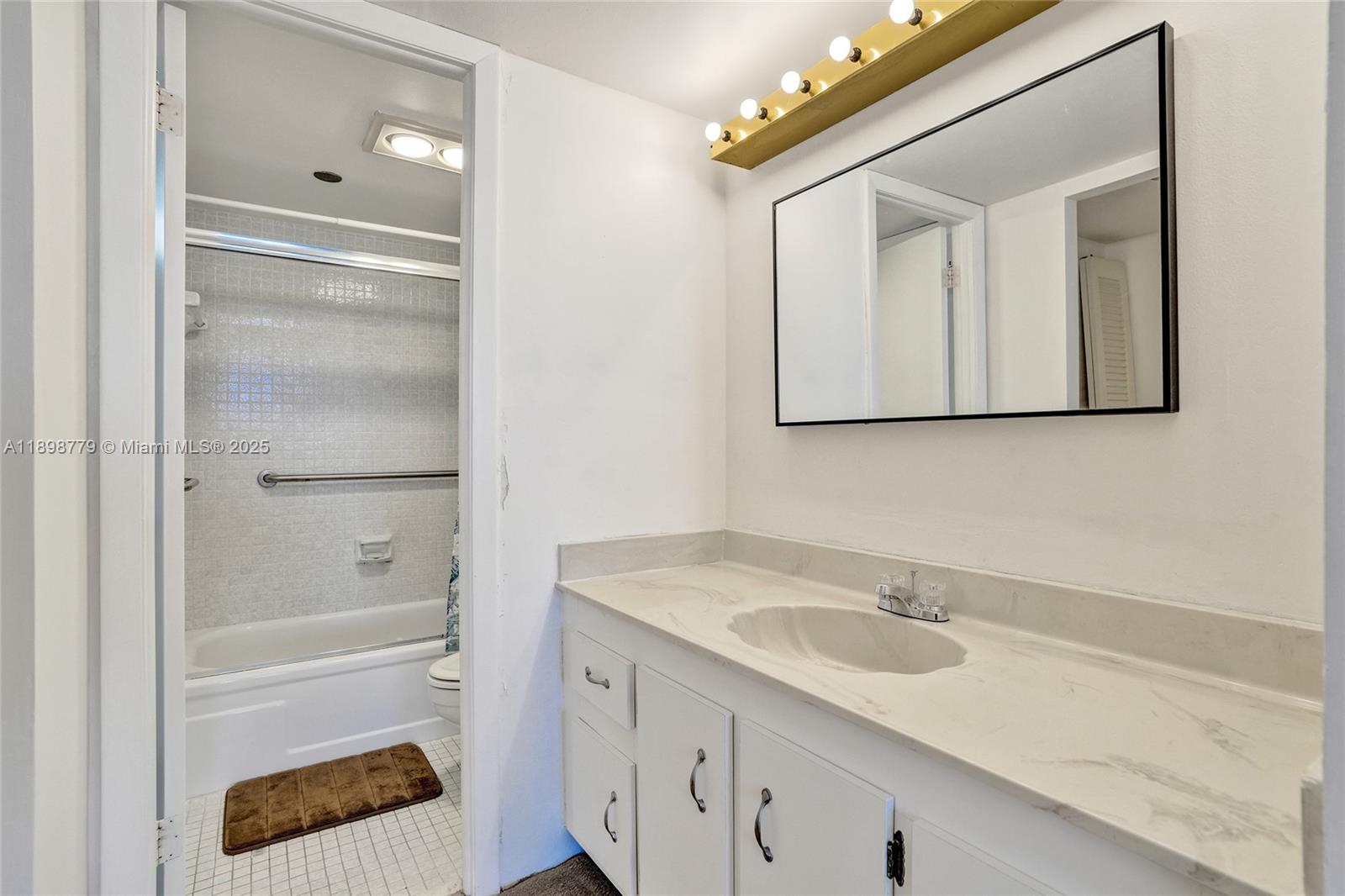 1200 St Charles Place, Unit 413 Pembroke Pines, FL 33026 - Photo 16 of 34 a bathroom with a sink and a mirror
