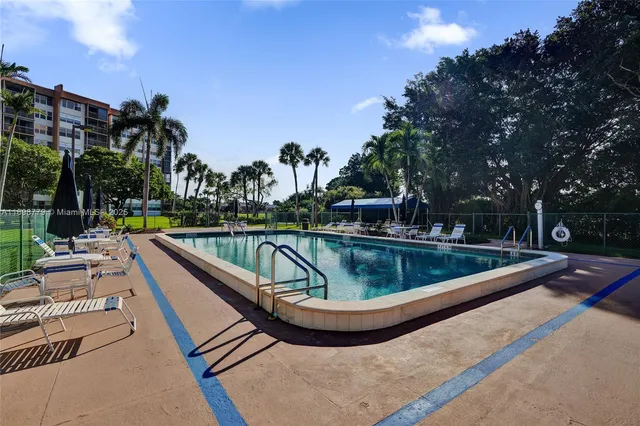 a view of a swimming pool with a patio and a yard