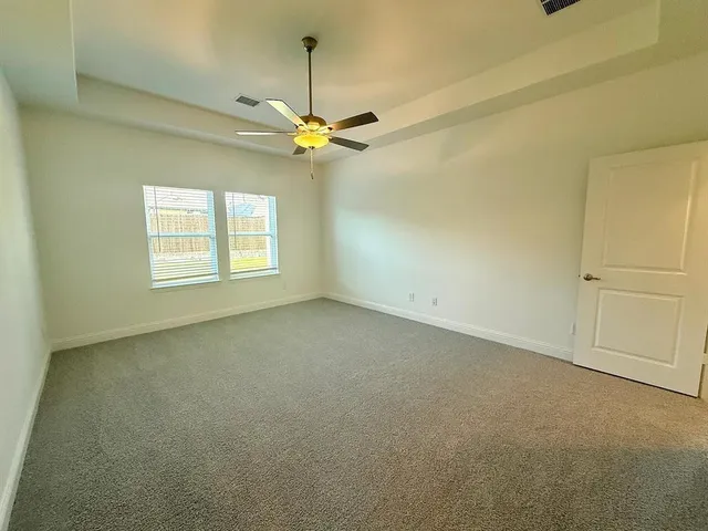 an empty room with windows and fan