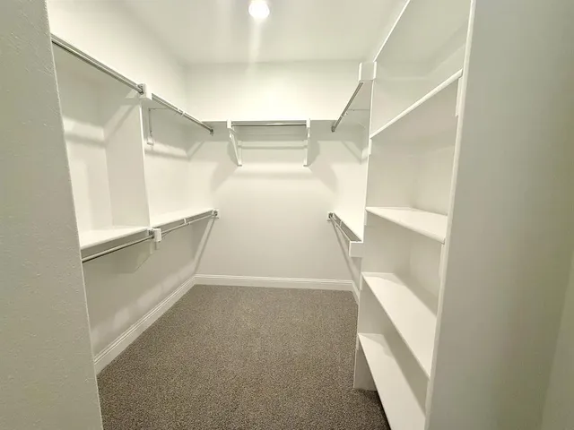 a view of walk in closet with empty racks