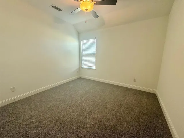 an empty room with a window and a fan