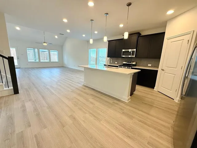a view of kitchen with sink microwave and refrigerator