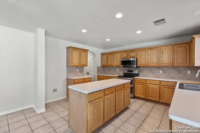 a kitchen with a sink window and stainless steel appliances