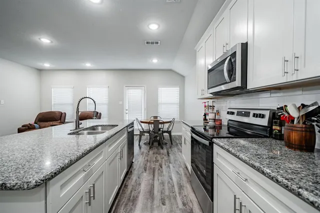 a kitchen with sink stove and cabinets