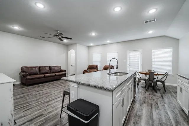 a living room with furniture a ceiling fan and a wooden floor