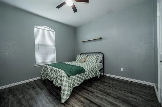 a bed sitting in a bedroom next to a window and a chandelier