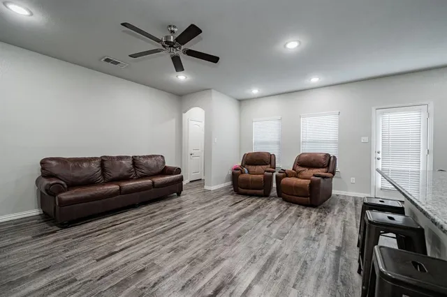 a living room with furniture and a wooden floor