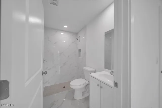 a bathroom with a toilet a sink and shower