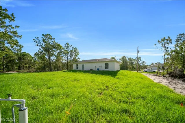 a backyard of a house with lots of green space and fountain