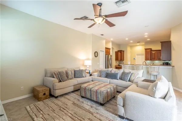 a living room with furniture and a view of kitchen