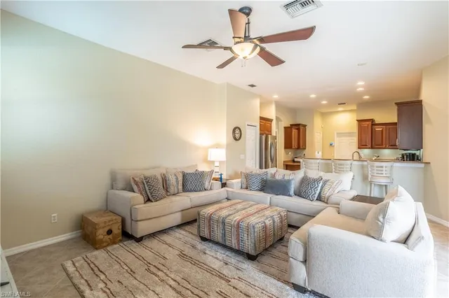 a living room with furniture and a view of kitchen