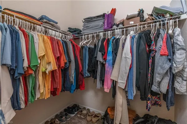 a view of walk in closet with clothes