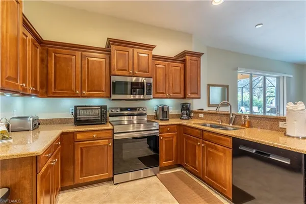 a kitchen with stainless steel appliances granite countertop a sink stove and microwave