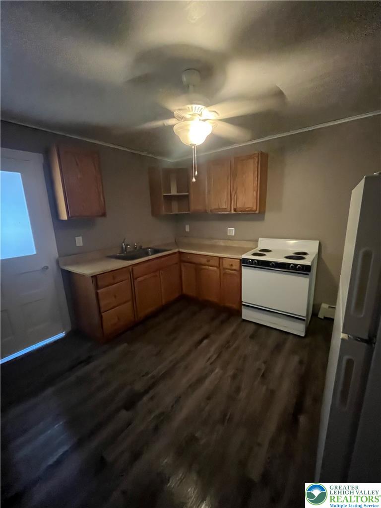 135 West Ridge Street Nesquehoning, PA 18240 - Photo 4 of 6 Classic wooden cabinetry pairs with durable wood-look flooring in this functional space.