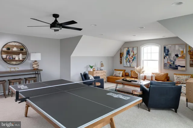 a living room with furniture a window and a fan