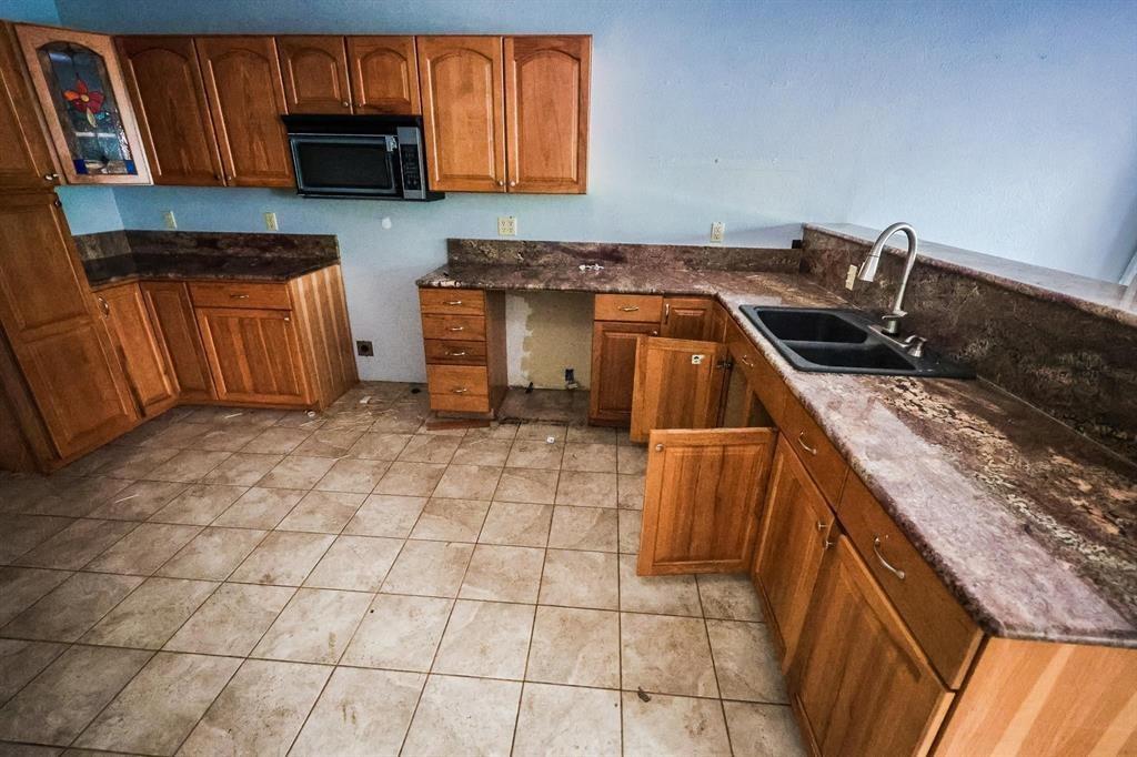 600 County Road 1503 Alba, TX 75410 - Photo 16 of 32 a kitchen with granite countertop a stove a sink and a microwave