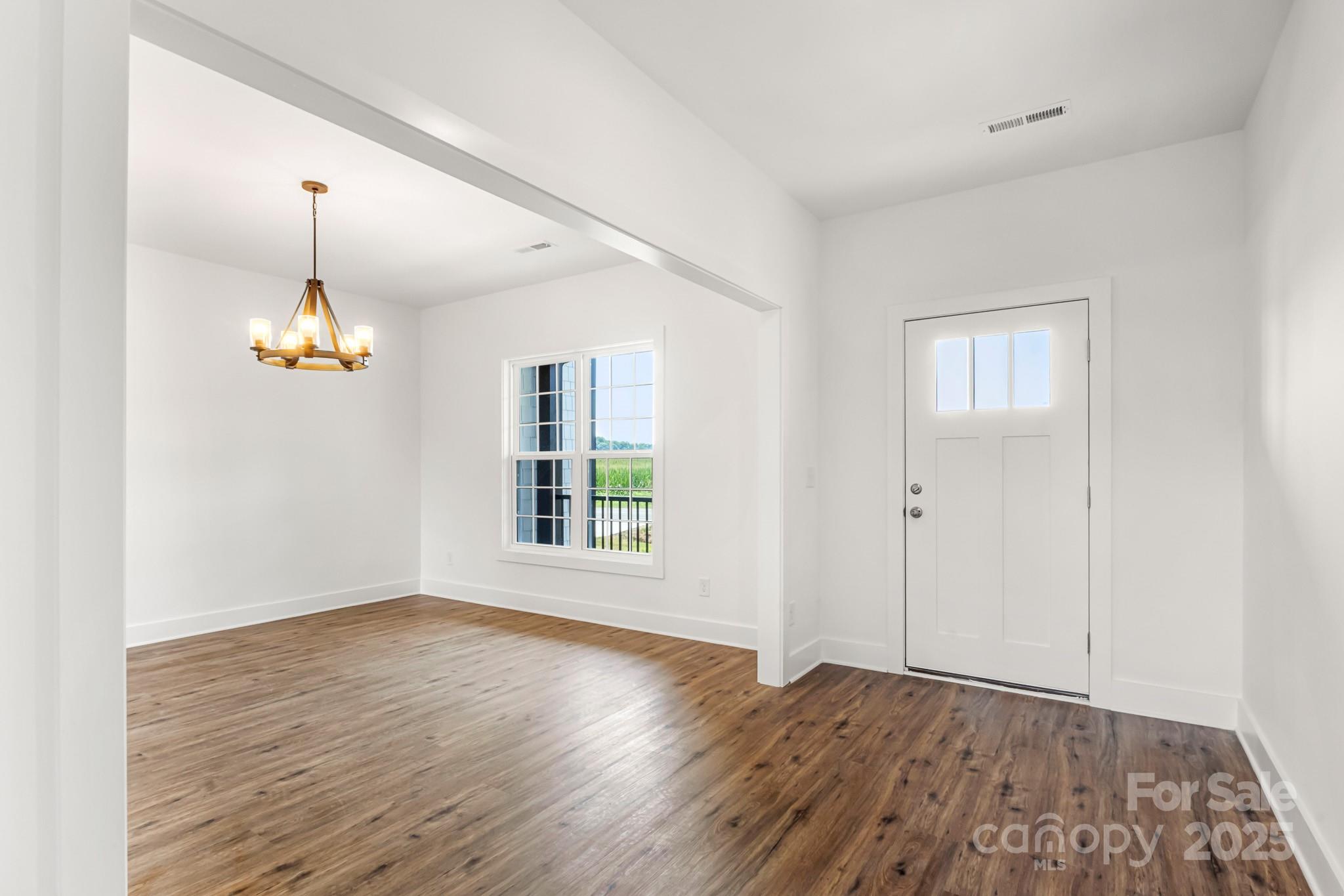 2025 Parks Road Salisbury, NC 28147 - Photo 3 of 47 an empty room with wooden floor ceiling fan and window