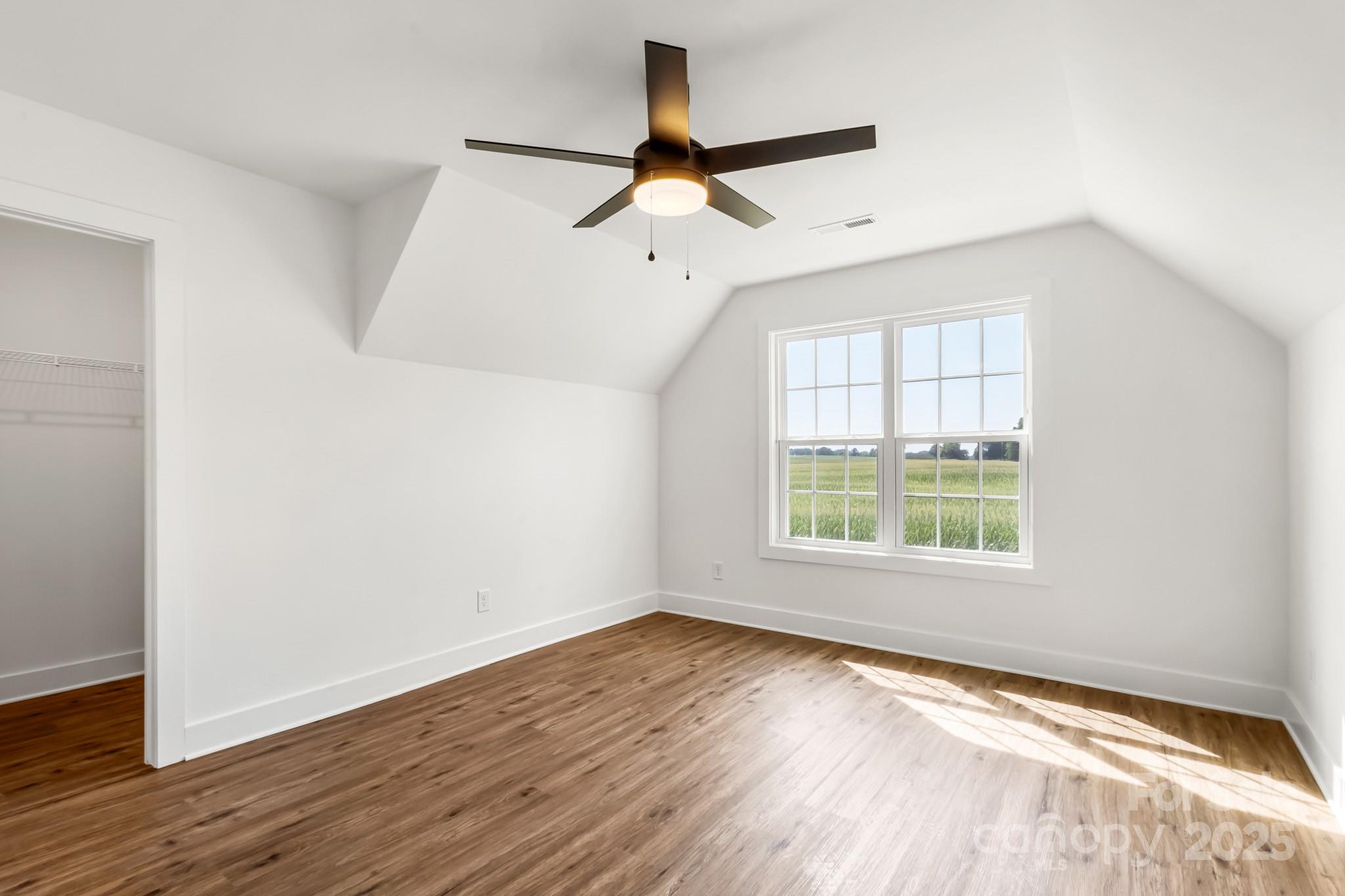 2025 Parks Road Salisbury, NC 28147 - Photo 42 of 47 an empty room with wooden floor ceiling fan and windows