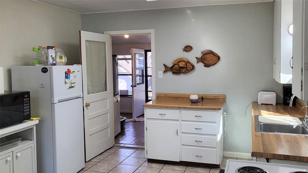 25208 Old Ferry Road Spicewood, TX 78669 - Photo 13 of 18 a kitchen with a refrigerator and cabinets