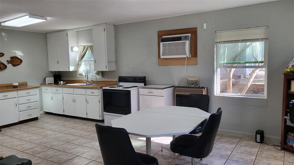 25208 Old Ferry Road Spicewood, TX 78669 - Photo 10 of 18 a kitchen with a table chairs sink and cabinets