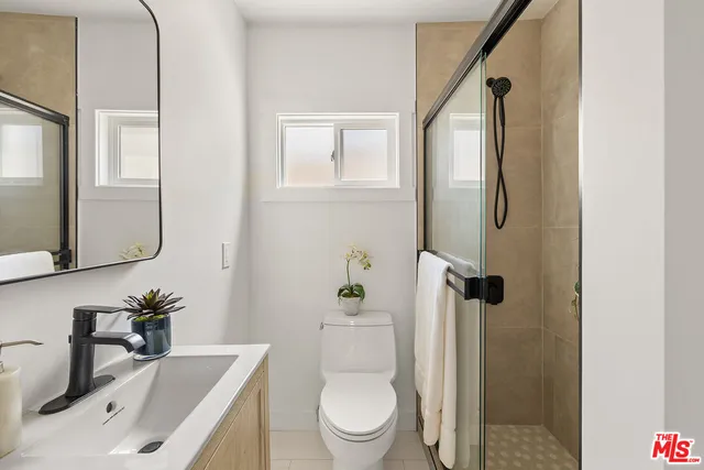 a bathroom with a sink a toilet and shower