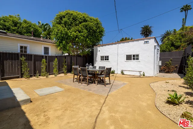 a view of a patio with a table and chairs under an umbrella