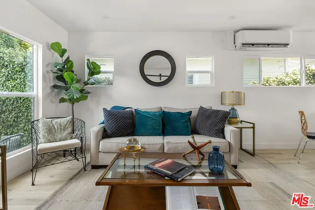a living room with furniture a window and a potted plant