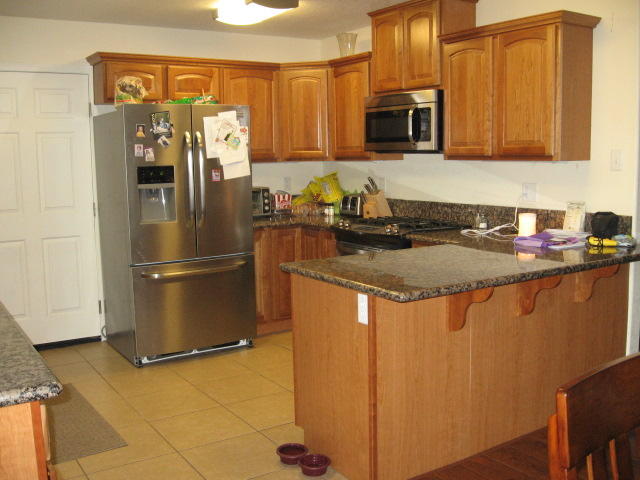 13471 Gilbert Street Edwards, CA 93523 - Photo 7 of 16 a kitchen with stainless steel appliances granite countertop a refrigerator a stove a sink and a microwave