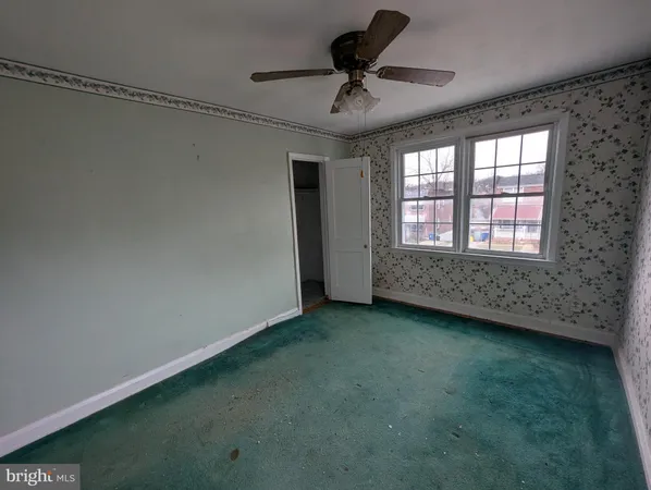 a view of a livingroom with a ceiling fan and window