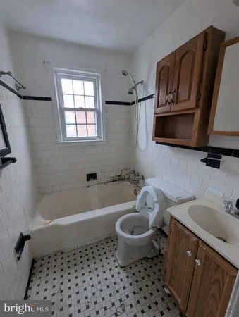 a bathroom with a granite countertop sink and a bathtub