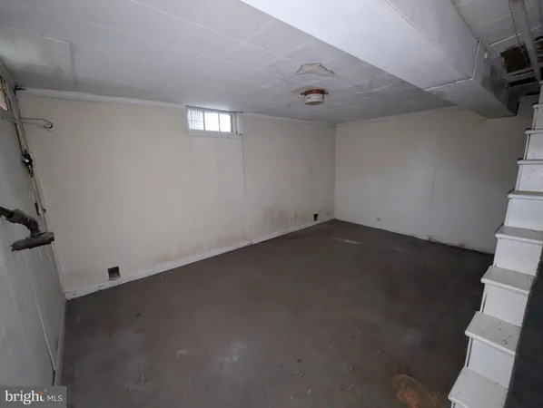 an empty room with a wooden floor and windows