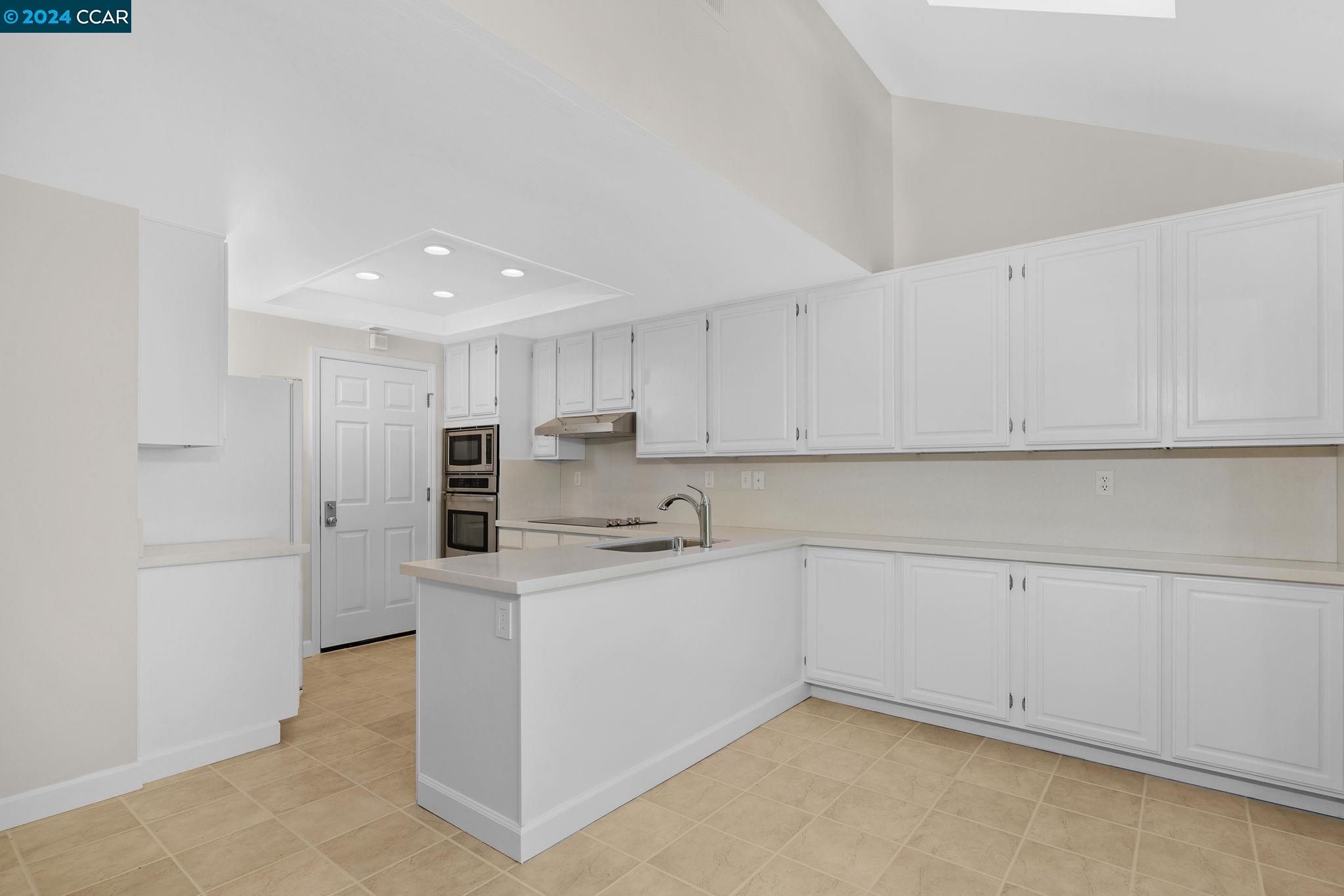 646 Preakness Drive Walnut Creek, CA 94597 - Photo 8 of 26 a kitchen with white cabinets and refrigerator