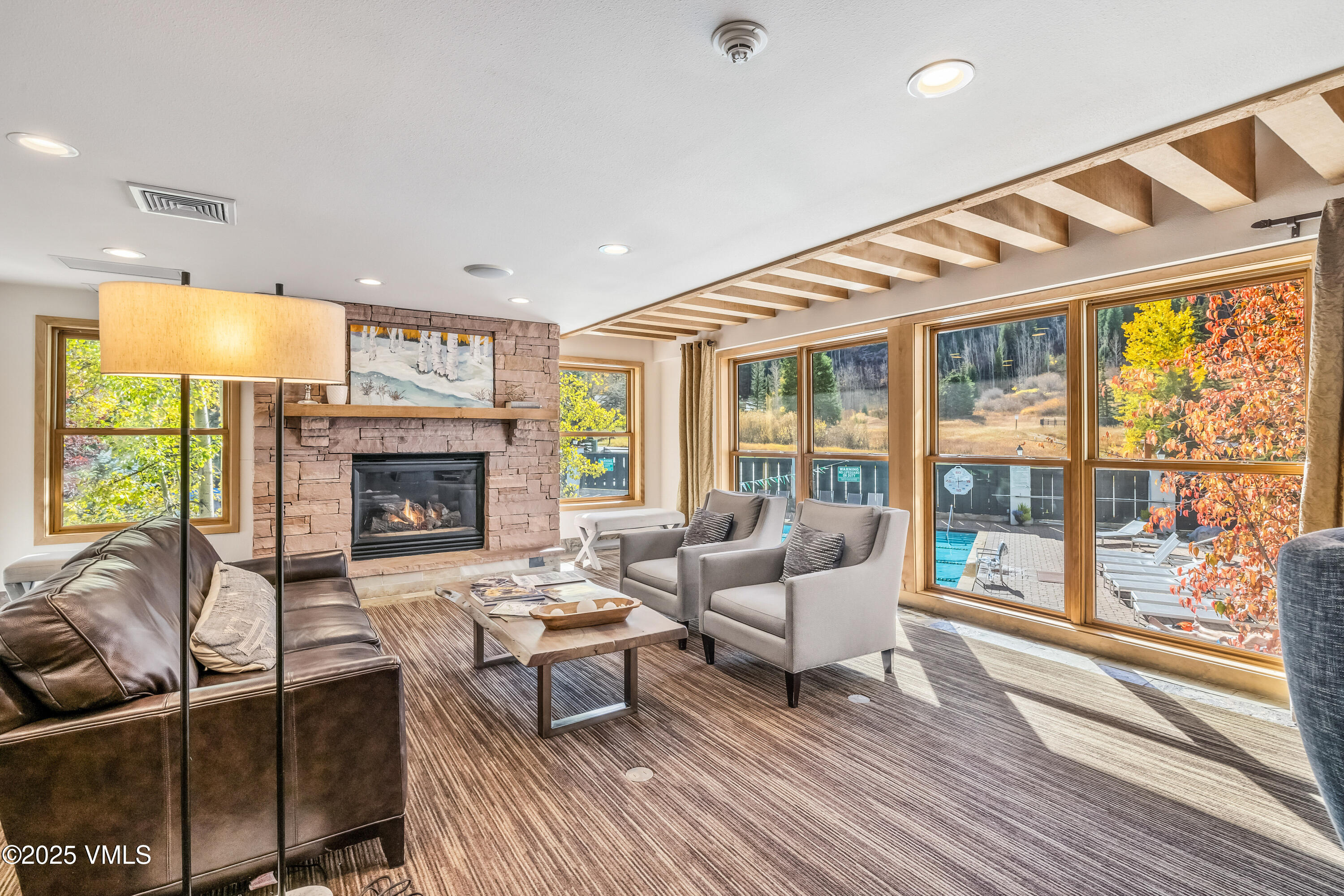 4630 Vail Racquet Club Drive, Unit 15 Vail, CO 81657 - Photo 13 of 20 a living room with furniture a fireplace and a floor to ceiling window