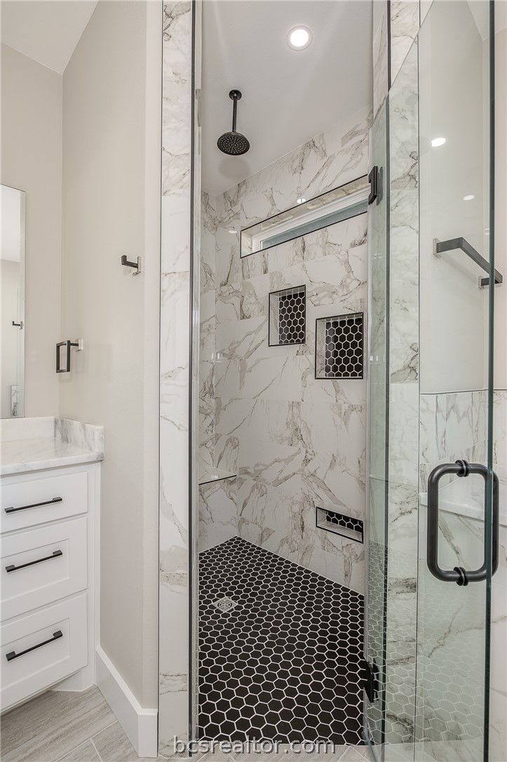 2908 GOLDBERG Drive Bryan, TX 77808 - Photo 33 of 44 Master bathroom retreat features walk in shower with decorative ceramic tile, bench seat and shampoo boxes and glass shower enclosure.
