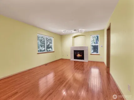 a view of empty room with wooden floor and fireplace