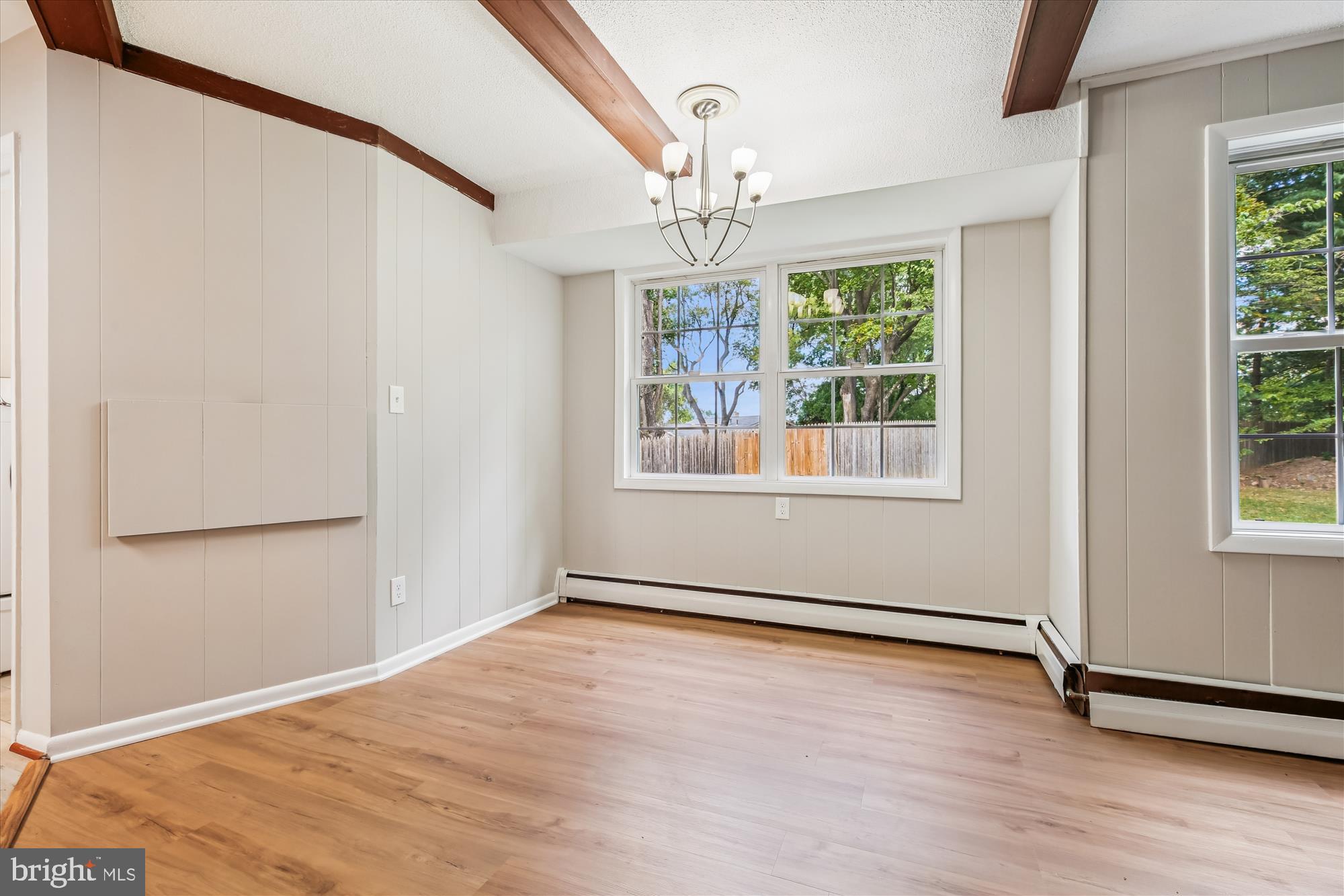 11803 Eden Road Silver Spring, MD 20904 - Photo 21 of 45 an empty room with wooden floor chandelier and windows