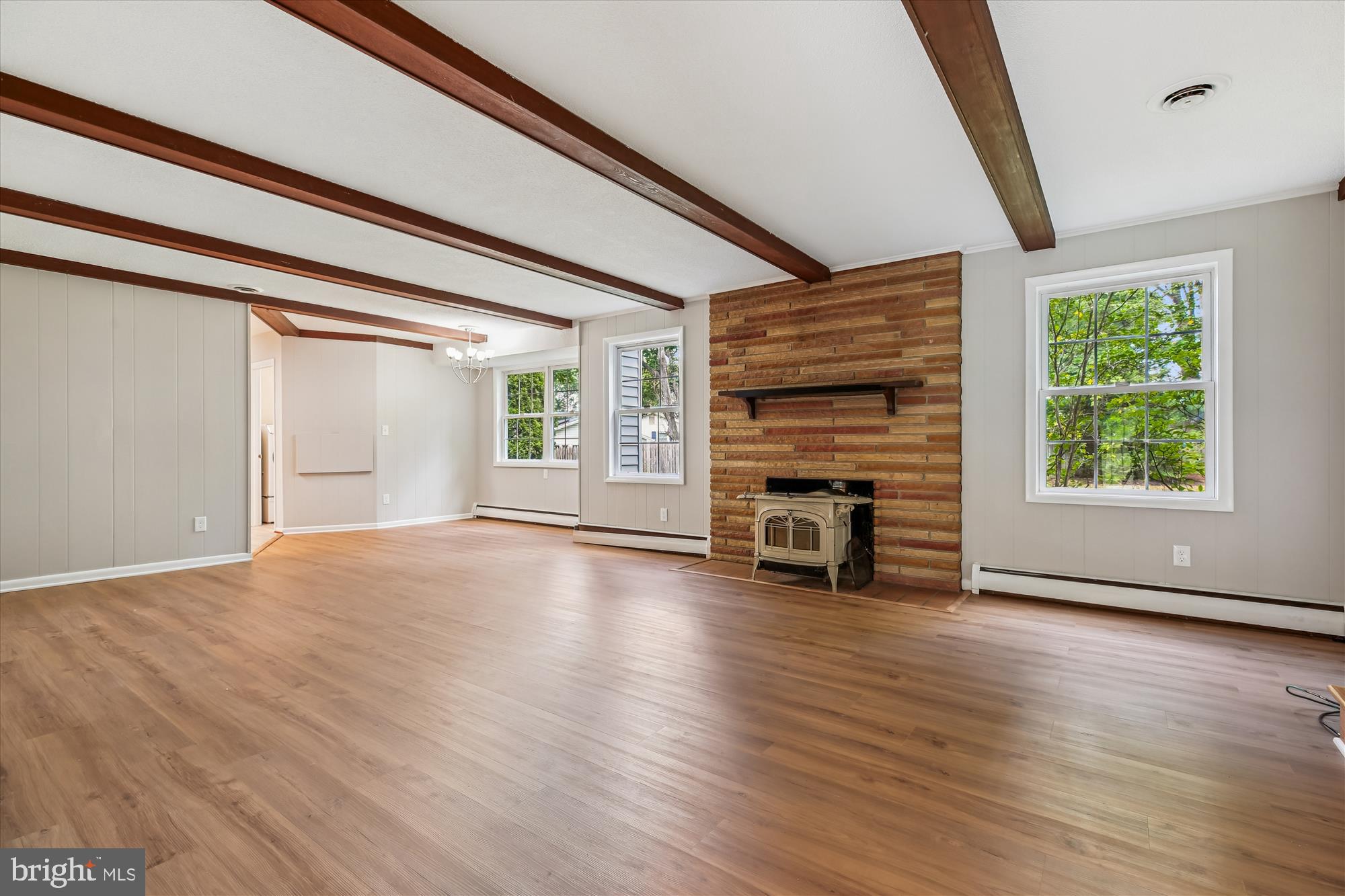 11803 Eden Road Silver Spring, MD 20904 - Photo 24 of 45 an empty room with wooden floor fireplace and windows