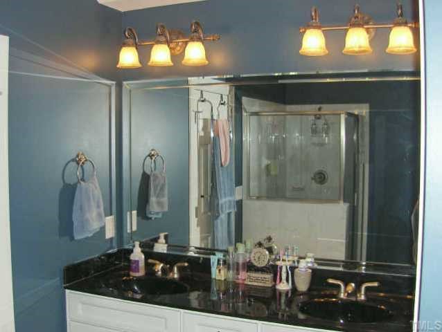 7362 Fontana Ridge Lane Raleigh, NC 27613 - Photo 8 of 10 a bathroom with a granite countertop sink a mirror and a shower