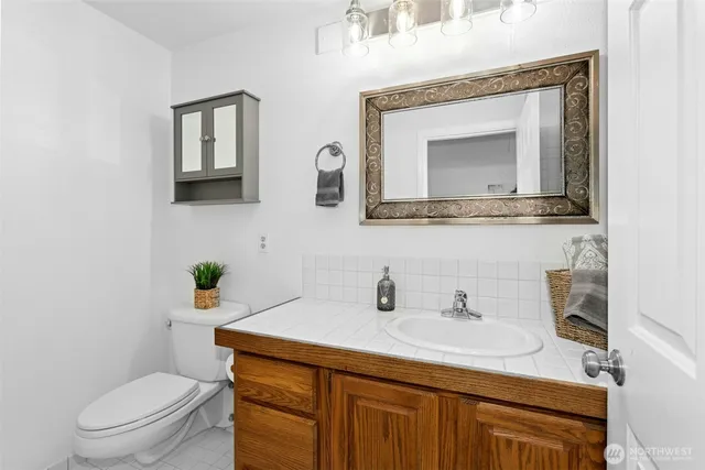 a bathroom with a toilet sink and mirror