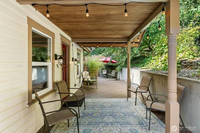 a patio with table and chairs and potted plants
