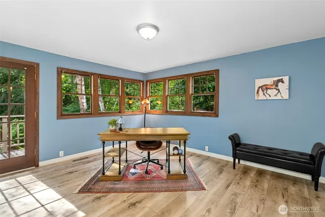 a work room with furniture a rug and a window