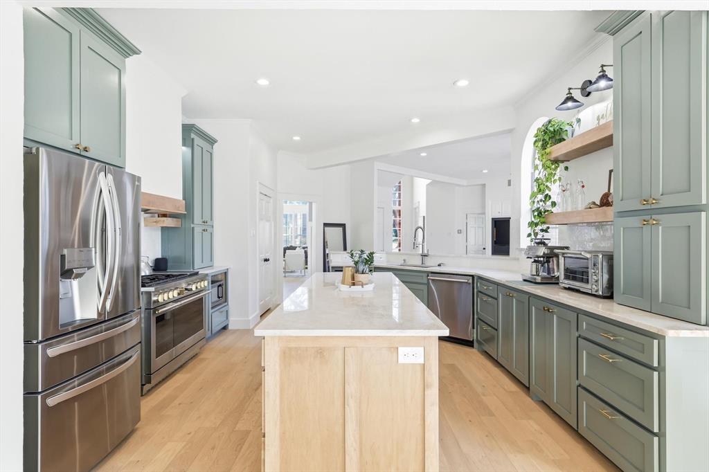 117 Sand Point Court Coppell, TX 75019 - Photo 13 of 40 a kitchen with stainless steel appliances granite countertop a refrigerator a stove and a sink