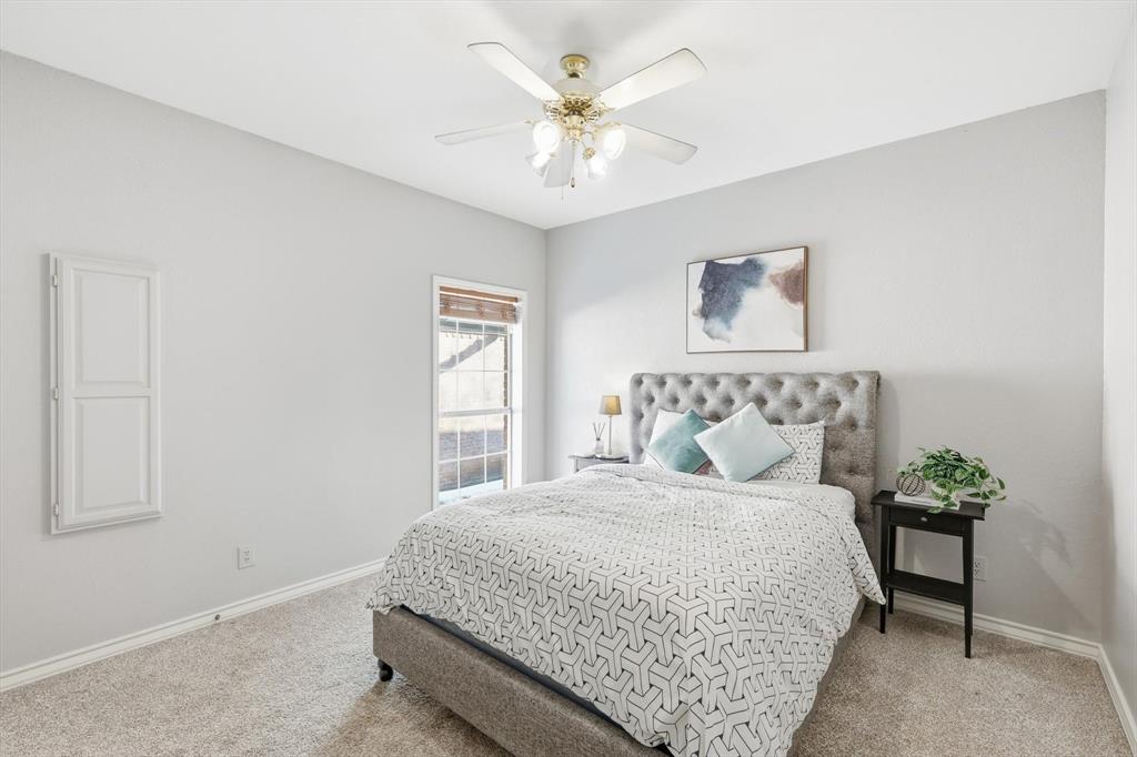 117 Sand Point Court Coppell, TX 75019 - Photo 26 of 40 a bedroom with a bed and a chandelier