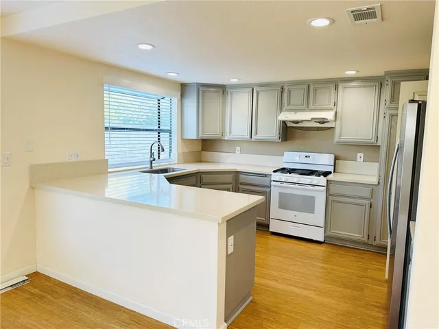 a kitchen with a sink appliances and cabinets