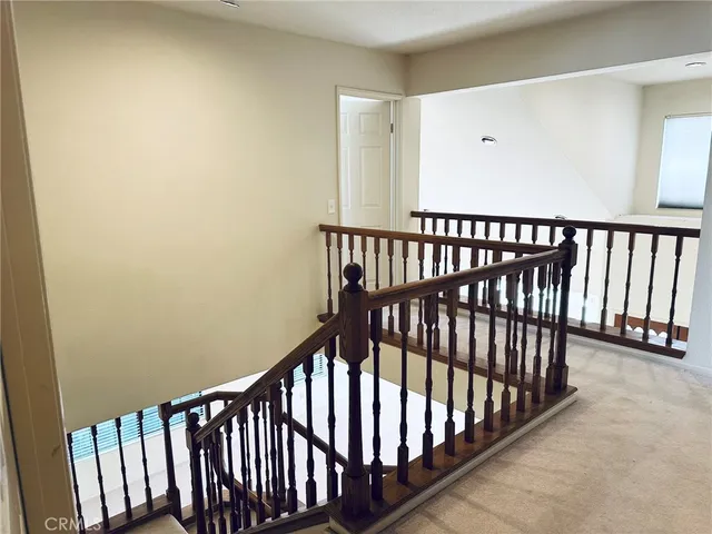 a view of staircase with railing and a window