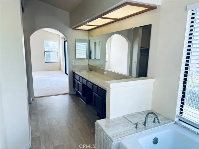 a spacious bathroom with a tub sink and mirror