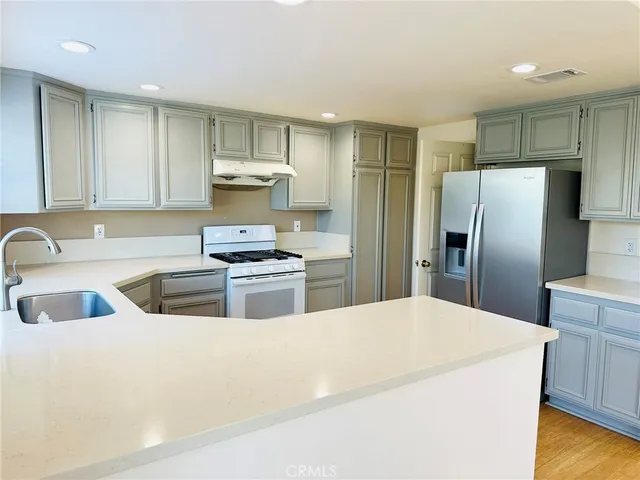a kitchen with refrigerator and cabinets